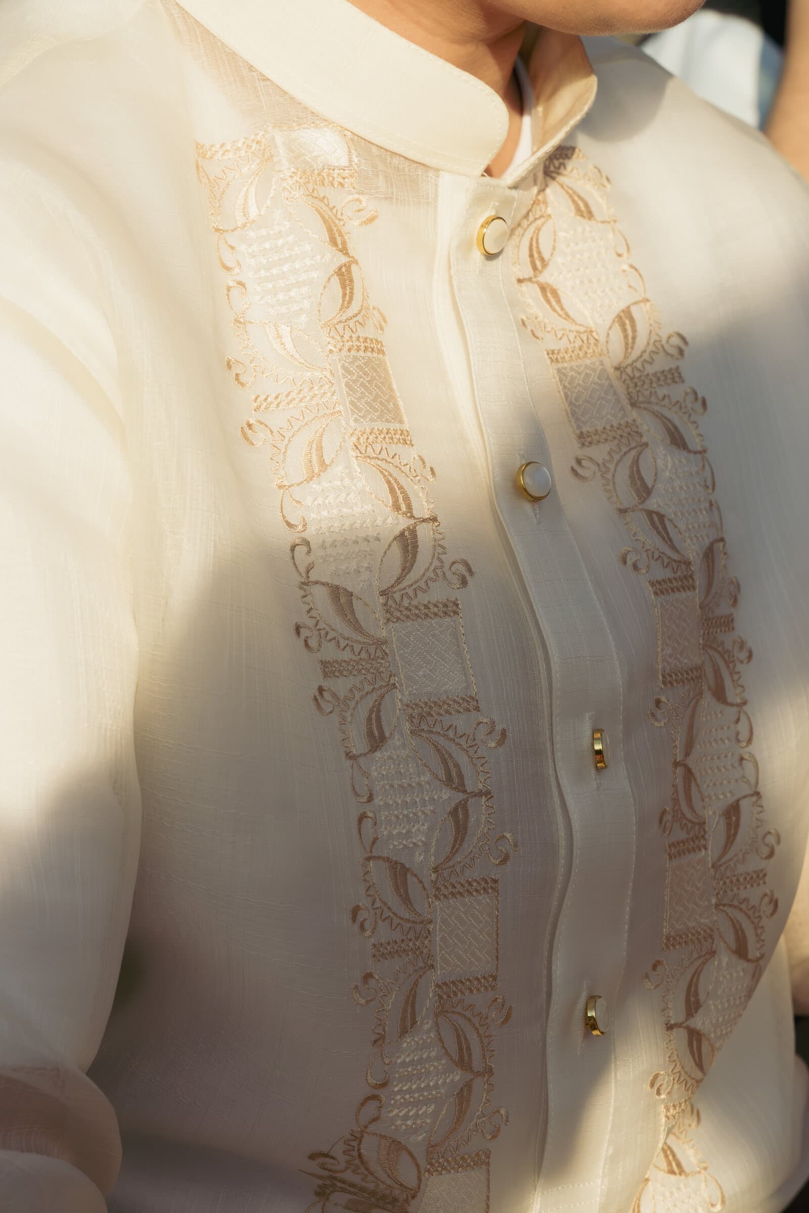 Embroidered barong detail in golden light