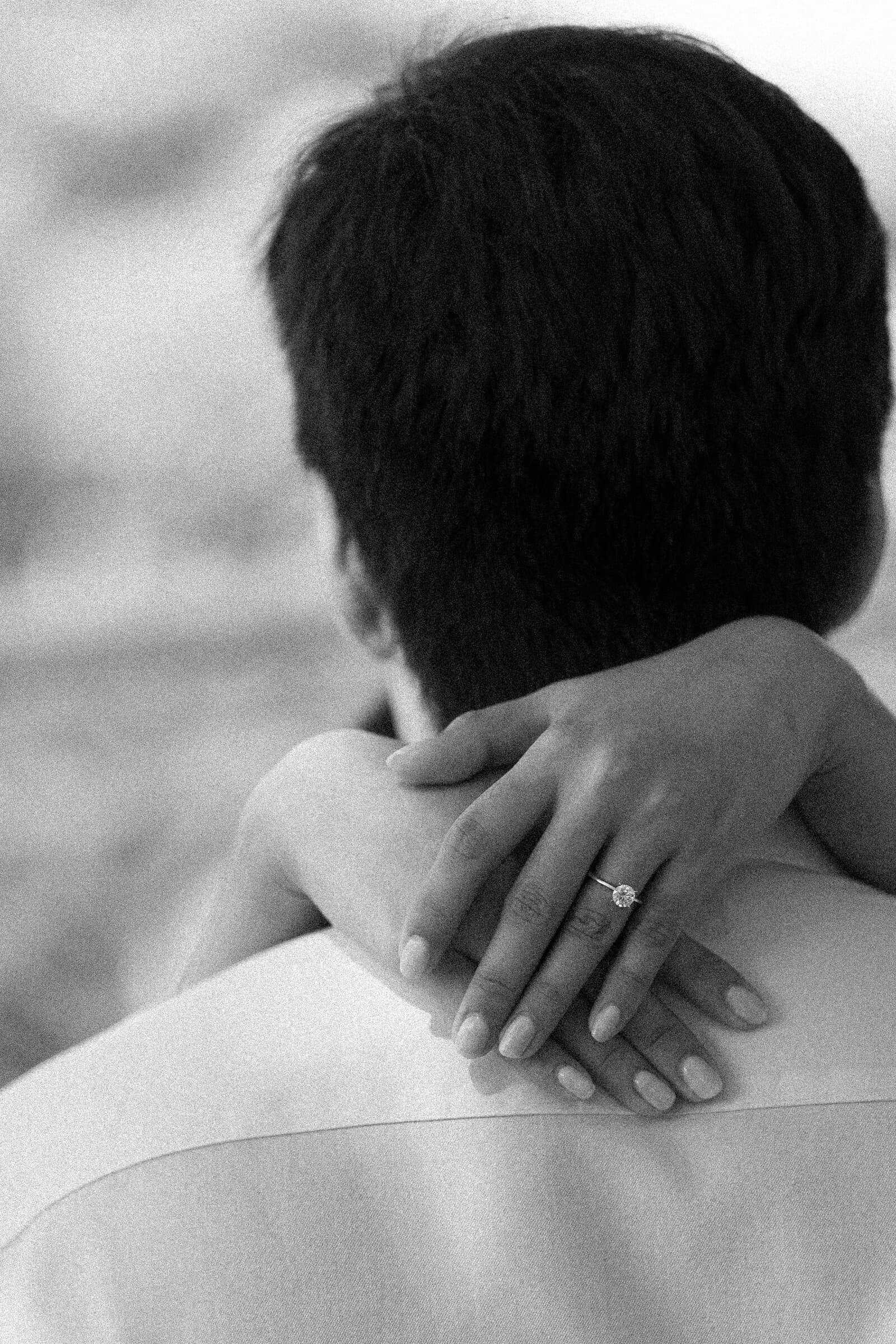 Embrace with an engagement ring, black and white
