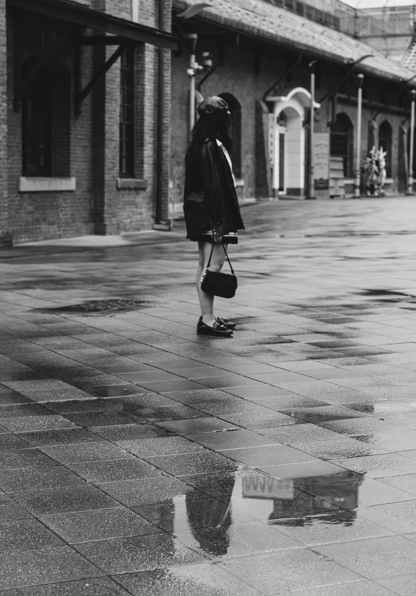 Figure on a rainy brick street, black and white