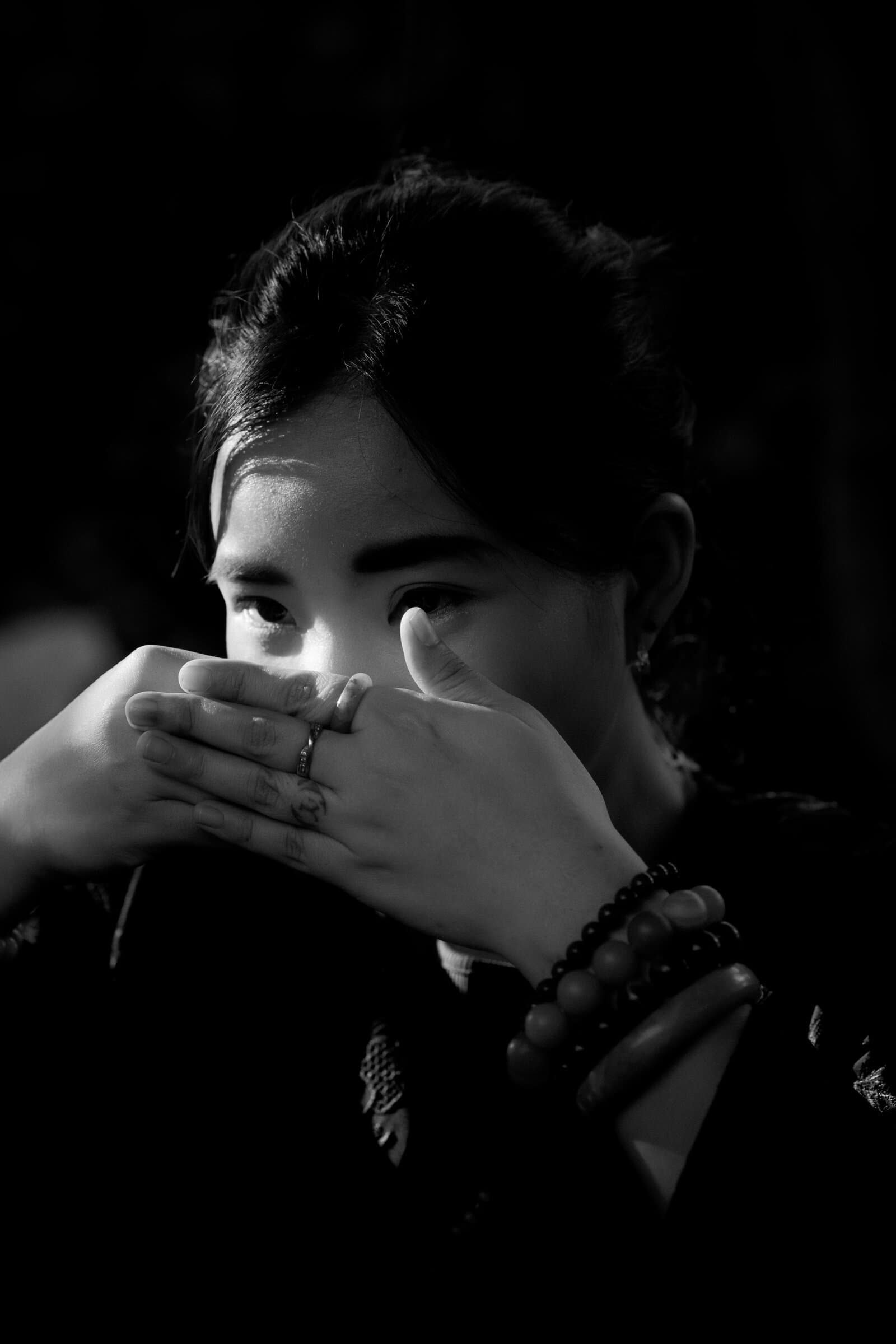 Guest cradling a tea cup, black and white