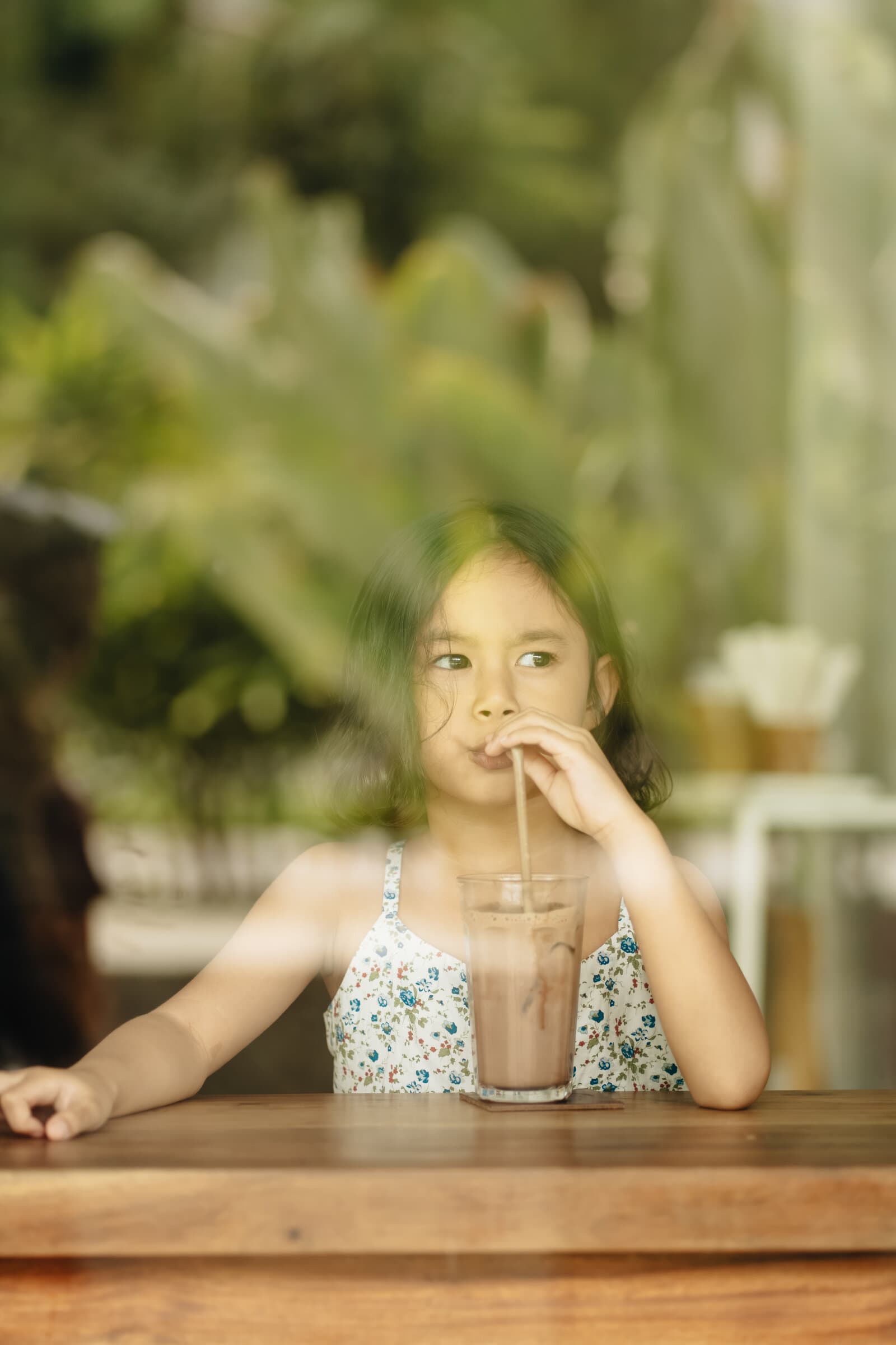 Girl sipping iced tea by the window