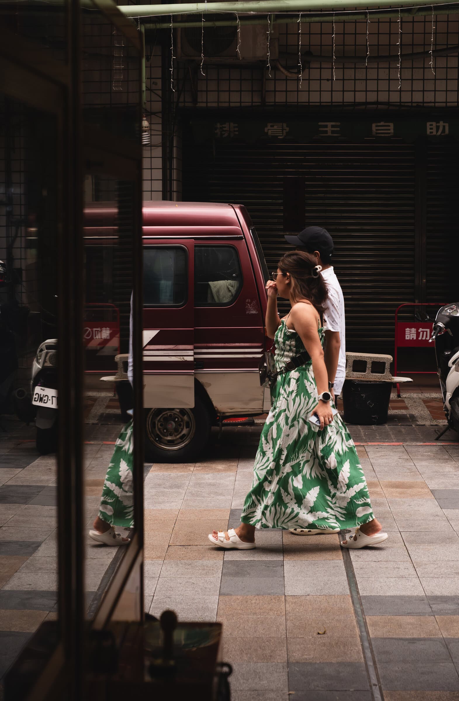 Street scene in a green dress, seen through glass